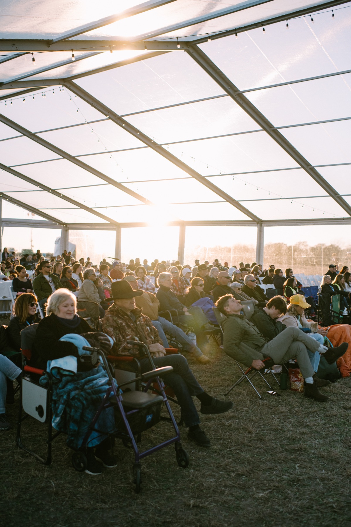 Crowd under the tent, sunset streaming through